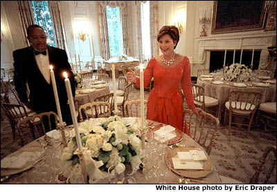 With just minutes to go before hosting her first State Dinner, Laura Bush lights the first candles of the evening with a little help from maitre d' George Hannie. White House photo by Eric Draper.