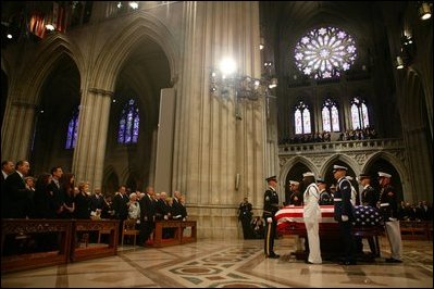 The casket of former President Ronald Reagan is surrounded by military service pall bearers at the funeral service at the National Cathedral in Washington, DC on June 11, 2004. 