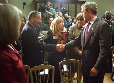 President George W. Bush talks with some of family members of those who were killed during the September 11 attacks after signing Intelligence Authorization Act in the Roosevelt Room, Wednesday, Nov. 27. The act of Congress will authorize intelligence programs and creating a national commission to investigate the events of September 11, 2001.