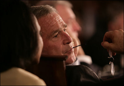President George W. Bush listens to Secretary of State Condoleezza Rice during the opening session Friday, Nov. 4, 2005, of the 2005 Summit of the Americas in Mar del Plata, Argentina.