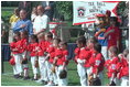 President George W. Bush and Cal Ripken stand for the singing of the national anthem during the opening ceremony of the first game of the White House Tee Ball season Sunday, May 5, 2002. Mr. Ripken is serving as the honorary commissioner of the White House T-ball League.