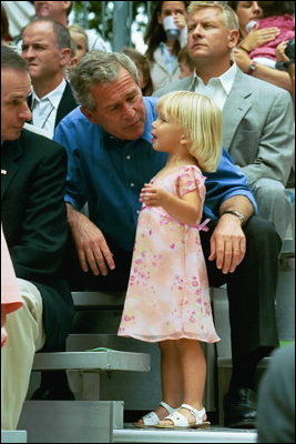 During the game, President Bush spends a few moments with a little league fan during the first game of the 2004 White House Tee Ball season June 13, 2004.