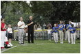 President George W. Bush stands with Cal Ripken Jr. for the National Anthem at Tee Ball on the South Lawn at the White House on Sunday July 11, 2004.