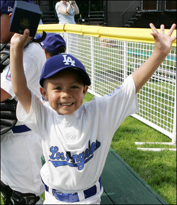 An excited member of the Wrigley Little League Dodgers of Los Angeles shows off his Presidential autographed baseball following their game against the Inner City Little League of Brooklyn, N.Y., Sunday, July 15, 2007, at the White House Tee Ball Game celebrating the legacy of Jackie Robinson on the South Lawn of the White House. Brooklyn and Los Angeles represent the two home cities of Robinson’s team.
