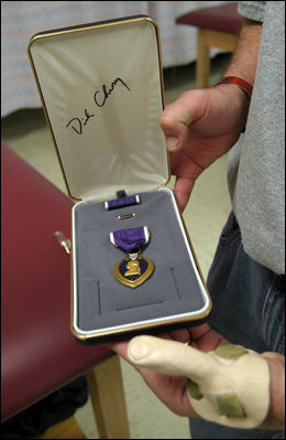 A wounded soldier displays his autographed Purple Heart after being awarded the medal by Vice President Dick Cheney at Walter Reed Medical Center in Washington, October 22, 2003. Initially created as the Badge of Military Merit by General George Washington, the Purple Heart is the oldest military decoration in the world in present use and the first American award made available to the common soldier.