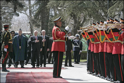 Vice President Dick Cheney is joined by President Hamid Karzai of Afghanistan for the playing of the national anthem of the United States Thursday, March 20, 2008, during an arrival ceremony at Gul Khana Palace in Kabul. While in Afghanistan the Vice President held meetings with President Karzai and visited Bagram Air Base for a classified briefing and dinner with U.S. troops.