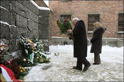 Vice President Dick Cheney, flanked by his daughter Liz Cheney, places a bouquet of flowers at the Wall of Death at the Auschwitz-1 Nazi concentration camp, near Krakow, Poland, Friday, Jan. 28, 2005. Vice President Cheney was there to take part in ceremonies commemorating the 60th Anniversary of the liberation of the Auschwitz camps. The Wall of Death was named for its use as the backdrop for firing squads where thousands of prisoners were executed while the camp was in operation.