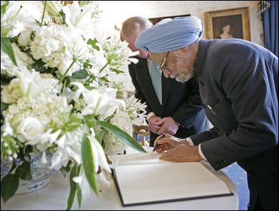India's Prime Minister Dr. Manmohan Singh is accompanied by U.S. Department of State Chief of Protocol Ambassador Donald Ensenat, Monday, July 18, 2005, as Singh signs the guest book upon his arrival to the White House. 