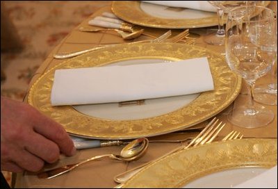 Last minute checks and adjustments are made on the table arrangements in the State Dining Room, Wednesday, Nov. 2, 2005, in preparations for the official dinner for the Prince of Wales and Duchess of Cornwall at the White House.