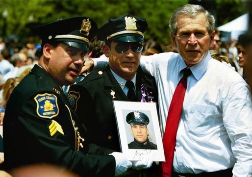 President George W. Bush stands for pictures during the Annual Peace Officers' Memorial Service at the U.S. Capitol in Washington, D.C., Saturday, May 15, 2004. "Our fallen officers died in service to justice, and in defense of the innocent," said President Bush. "They will never be forgotten by their comrades, they will never be forgotten by their country." White House photo by Paul Morse