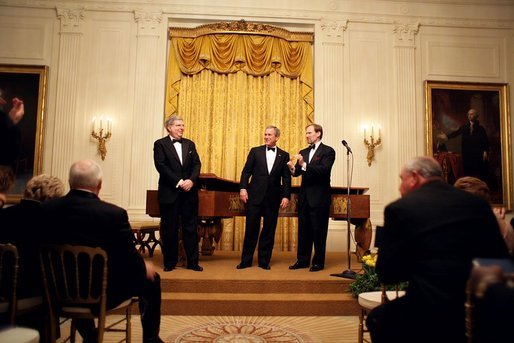 President George W. Bush thanks composer Marvin Hamlisch, left, and entertainer Mark McVey for their performance during the state dinner for the National Governors Association at the White House Sunday, Feb. 27, 2005. White House photo by Paul Morse