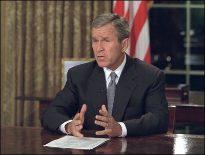 Sitting at his desk in the Oval Office, President Bush addresses the nation on the evening of Sept. 11, 2001.