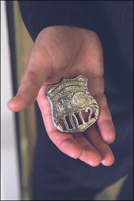 President Bush holds the badge of Officer George Howard. 