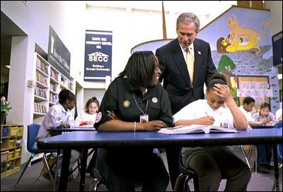 While encouraging Americans to serve their community through the USA Freedom Corps, President Bush talks with mentors and students at the South End Community Center in Bridgeport, Conn., April 9, 2001.