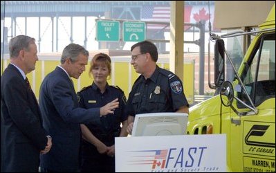 With Canadian Prime Minister Jean Chretien, President Bush listens to a demonstration of a border security technology called "Free and Secure Trade (FAST) Lane" at the U.S.-Canadian border in Detroit, Sept. 9, 2002. 