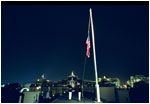 U.S. Marines lower the American flag flying over the White House to half staff at midnight Tuesday, September 10, 2002 to mark the anniversary of September 11. Pictured in the background is the Eisenhower Executive Office Building.