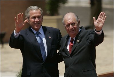 President George W. Bush waves with Chilean President Ricardo Lagos upon his arrival at the APEC CEO Summit in Santiago, Chile, Nov, 20, 2004. 