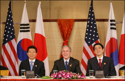 President George W. Bush sits with President Roh Moo-Hyun, of the Republic of Korea, left, and Japan's Prime Minister Shinzo Abe during a trilateral discussion Saturday, Nov. 18, 2006, at the Sheraton Hanoi hotel in Hanoi, where they are participating in the Asia Pacific Economic Cooperation summit.