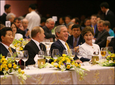 President George W. Bush and Mrs. Laura Bush enjoy the APEC gala dinner and cultural performance Saturday, Nov. 18, 2006, at the National Convention Center in Hanoi. They are seated with President Vladimir Putin of Russia, and President Roh Moo-hyun of the Republic of Korea, left.
