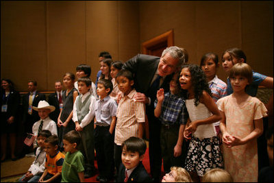 President George W. Bush joins kids of U.S. Embassy staff for a photo at the Sheraton Hanoi Saturday, Nov. 18, 2006.