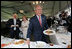 With Australia's Prime Minister John Howard and his wife, Janette Howard, smiling in the background, President George W. Bush kids with members of the media Wednesday, Sept. 5, 2007, during a luncheon with Australian troops on Garden Island in Sydney.