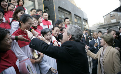 President George W. Bush reaches out to church members Sunday, Nov. 20, 2005, at the Gangwashi Church in Beijing after he and Mrs. Bush attended services.