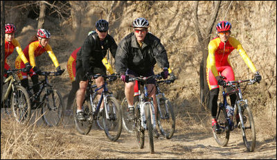 President George W. Bush leads the pack as he joins China's Mountain Biking Team for a ride Sunday afternoon, Nov. 20, 2005, in Beijing.
