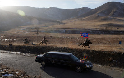 Mongolian horsemen run with the motocade carrying President George W. Bush and Mrs. Bush to a cultural event in Ikh Tenger, Mongolia Monday, Nov. 21, 2005. The stop in Mongolia was the final one for the Bushes in a 7-day visit to Asia. 