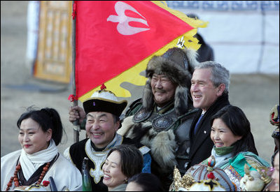 President George W. Bush poses for photos with a Mongolia horseman and other participants of a cultural event in Ikh Tenger, near the capital city of Ulaanbaatar, during a visit Monday, Nov. 21, 2005, by the President and Mrs. Bush. 