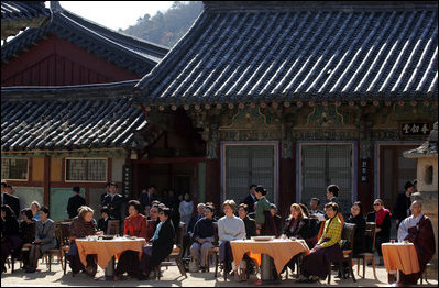 Sitting in the Korean sunlight, Laura Bush is joined by spouses of APEC leaders at the Beomeosa Temple in Busan for a morning tea ceremony.