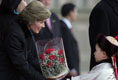 A young boy delivers a bouquet of flowers to Mrs. Bush Monday, Nov. 21, 2005, as she and President Bush joined Mongolia's President and First Lady in ceremonies in Ulaanbaatar welcoming the Bushes to Mongolia.