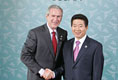 President George W. Bush shakes hands with President Moo Hyun Roh of the Republic of Korea as President Roh welcomes him to the 2005 APEC conference in Busan.