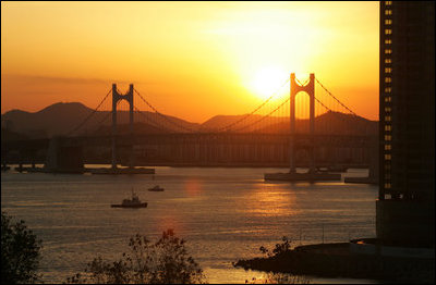 The sun sets over Busan's Gwangan Grand Bridge Friday, Nov. 18, 2005.