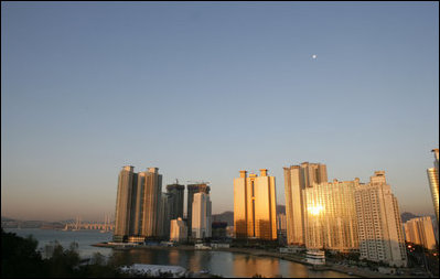 The moon sits over the Gwangan Grand Bridge and the city of Busan, Korea, sight of the 2005 APEC summit.