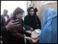 Agriculture Secretary Ann M. Veneman speaks to a woman who receives inexpensive bread from a WFP-funded women's bakery.