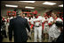 President George W. Bush shakes the hand of veteran player and Manager Frank Robinson Thursday, April 14, 2005, as members of the Washington Nationals, including left fielder Brad Wilkerson, right, applaud.  The President tossed the ceremonial first pitch at the season opener that marked the return of baseball to the nation's capitol.