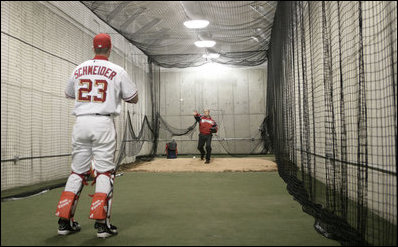 President George W. Bush and Washington Nationals catcher Brian Schneider warm up behind the scenes Thursday night at RFK Stadium.  The President threw out the ceremonial first pitch at the inaugural appearance of the baseball team.