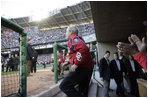 President George W. Bush acknowledges the applause as he exits the dugout Thursday, April 14, 2005, to throw out the first pitch at the Washington Nationals' home opener.  The President's appearance proved good luck as the Nationals defeated the Arizona Diamondbacks, 5-3.