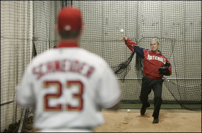 President George W. Bush warms up in preparation for his first pitch Thursday night, April 14, 2005, at RFK Stadium where the Washington Nationals made their inaugural home appearance.  Catching is Nationals' Brian Schneider.
