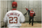President George W. Bush warms up in preparation for his first pitch Thursday night, April 14, 2005, at RFK Stadium where the Washington Nationals made their inaugural home appearance.  Catching is Nationals' Brian Schneider.