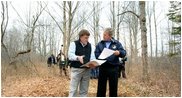 President George W. Bush looks over maps of the Wells National Estuarine Research Reserve with Manager Paul Dest in Wells, Maine, Thursday, April 22, 2004.