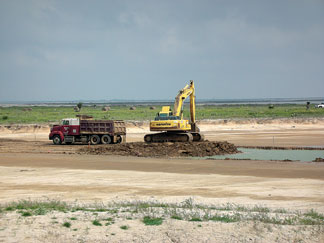 Heavy equipment operators remove excess material to create one of the channels connecting the three basins within the Bahia Grande wetland complex, Texas. (Thor Lassen, Ocean Trust)