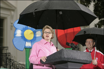 Education Secretary Margaret Spellings and Health and Human Services Secretary Mike Leavitt address soggy visitors to the 2005 White House Easter Egg Roll on the South Lawn Monday, March 28, 2005.