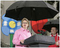 Education Secretary Margaret Spellings and Health and Human Services Secretary Mike Leavitt address soggy visitors to the 2005 White House Easter Egg Roll on the South Lawn Monday, March 28, 2005.^M