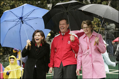 Jacalyn Leavitt, her husband, Health and Human Services Secretary Mike Leavitt and Education Secretary Margaret Spellings watch children run, fall and laugh as they run and slide on the South Lawn grass during the 2005 White House Easter Egg Roll.