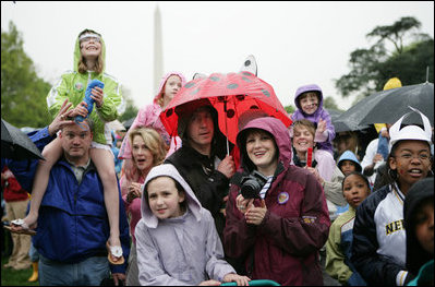 Guests brave a steady rain on the South Lawn of the White House during the 2006 White House Easter Egg Roll, Monday, April 17, 2006.