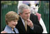 President George W. Bush embraces Mrs. Laura Bush as he blows a whistle Monday, March 24, 2008 on the South Lawn of the White House, to officially start the festivities for the 2008 White House Easter Egg Roll.