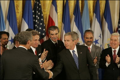 El Presidente George W. Bush estrecha la mano de legisladores, funcionarios del gobierno e invitados el martes, 2 de agosto de 2005 en el East Room de la Casa Blanca después de la ceremonia de promulgación de la CAFTA Implementation Act.