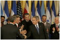 El Presidente George W. Bush estrecha la mano de legisladores, funcionarios del gobierno e invitados el martes, 2 de agosto de 2005 en el East Room de la Casa Blanca después de la ceremonia de promulgación de la CAFTA Implementation Act.