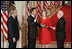 El Presidente George W. Bush observa el jueves, 29 de septiembre de 2005 en el East Room de la Casa Blanca en Washington mientras el Juez John G. Roberts toma el cargo de Presidente de la Corte Suprema ante el Juez de la Corte Suprema John Paul Stevens. La esposa del Juez Roberts, Jane, sostiene La Biblia.